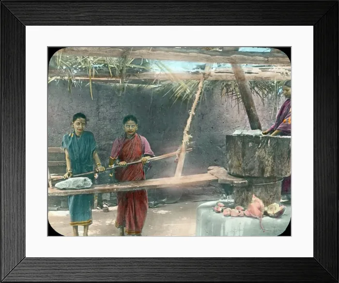 Framed Print : Indien. Hier werden Kokosnüsse von zwei Frauen zermahlen.