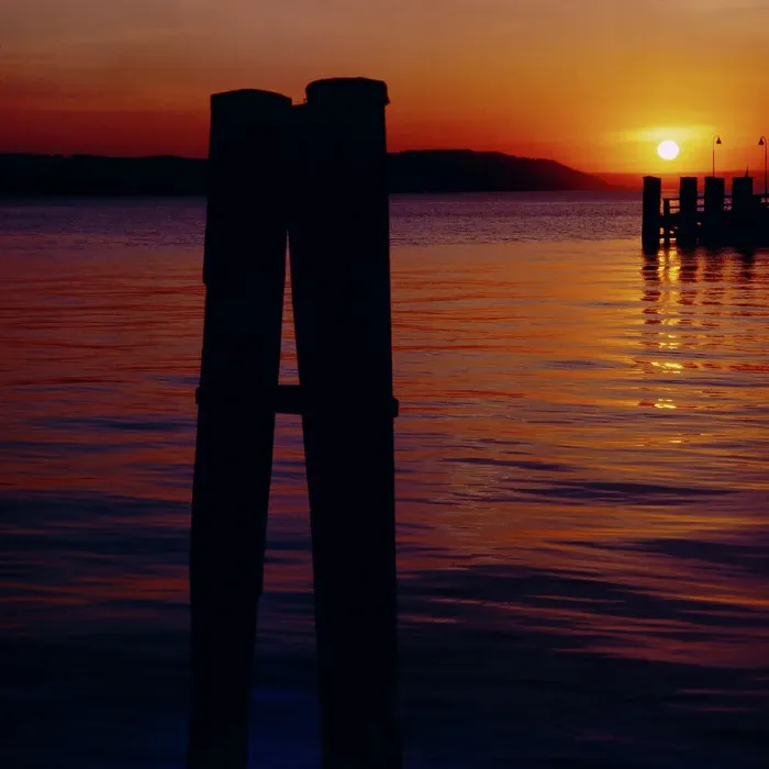 Gerahmter Druck : Bodensee. Ein Anlegepfeilerpaar genießt den Sonnenuntergang am Bodensee Gerahmter Druck : Bodensee. Ein Anlegepfeilerpaar genießt den Sonnenuntergang am Bodensee