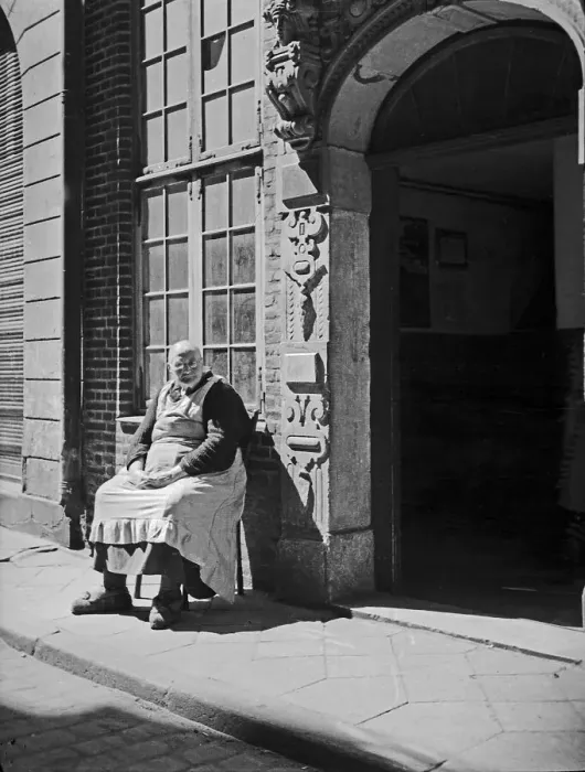 Impression encadrée : Danzig. Une vieille femme s'assoit devant une entrée de maison ensoleillé Impression encadrée : Danzig. Une vieille femme s'assoit devant une entrée de maison ensoleillé