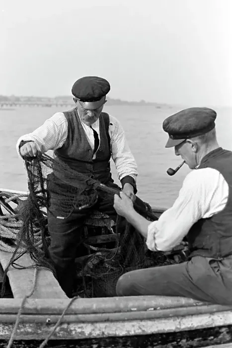 Gerahmter Druck : Fischer sortieren ihre Netze vor dem Fischfang in der deutschen Ostsee 1939.