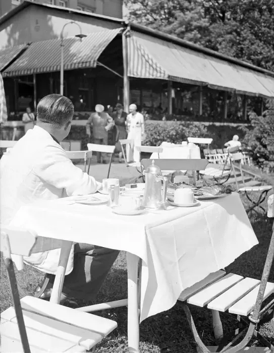 Gerahmter Druck : Freizeit. Ein Mann sitzt in der Außengastronomie im Garten eines Restaurants Gerahmter Druck : Freizeit. Ein Mann sitzt in der Außengastronomie im Garten eines Restaurants