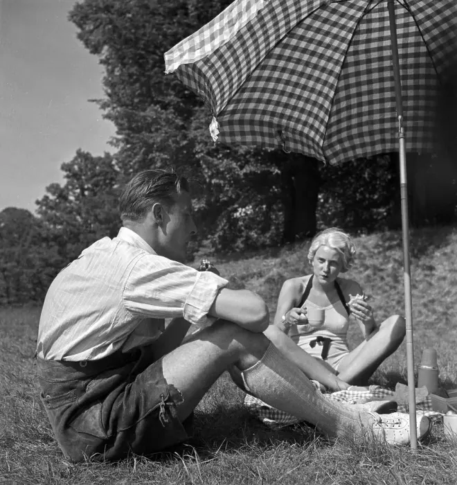 Stampa con cornice : Freizeit. Un uomo e una donna si trovano al picnic sotto un ombrellino Stampa con cornice : Freizeit. Un uomo e una donna si trovano al picnic sotto un ombrellino