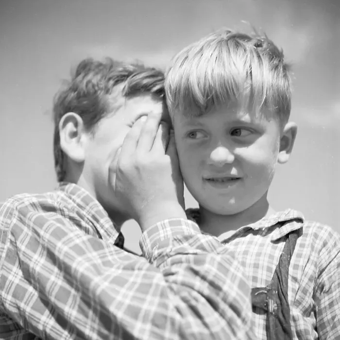 Gerahmter Druck : Kinder. Ein Junge flüstert etwas einem anderen zu Gerahmter Druck : Kinder. Ein Junge flüstert etwas einem anderen zu