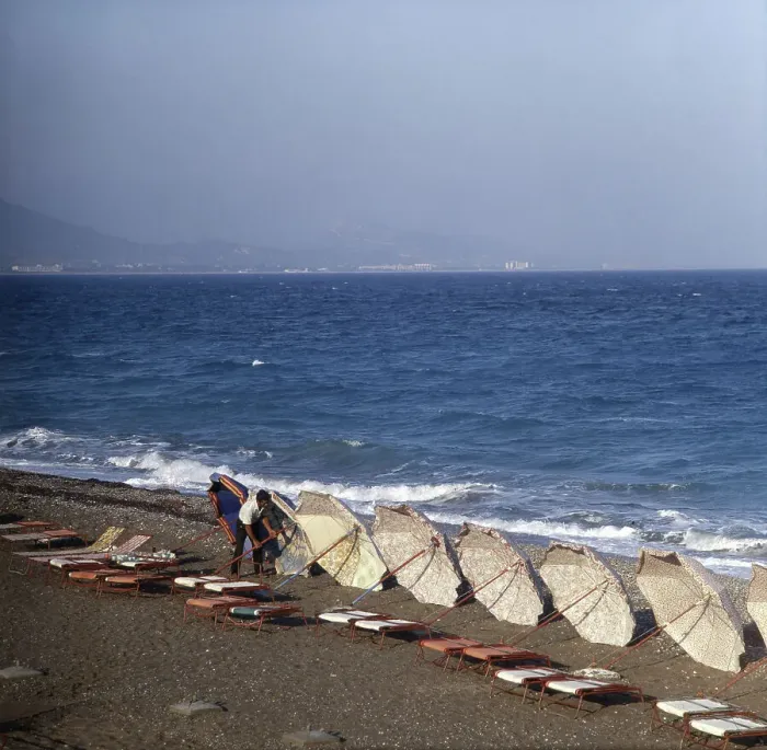Stampa con cornice : Un uomo raccoglie gli ombrelli dal mare negli anni '80. Stampa con cornice : Un uomo raccoglie gli ombrelli dal mare negli anni '80.