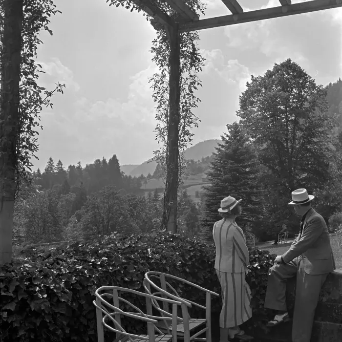 Gerahmter Druck : Wildbad. Ein Mann und eine Frau stehen in einem Pavillon eines Gartens
