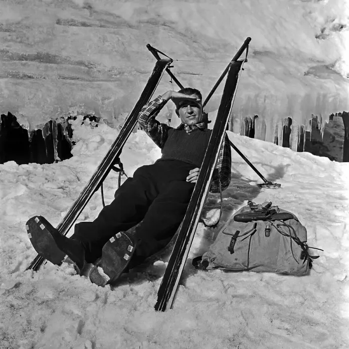 Stampa con cornice : Winter. Un turista di sci ha costruito un seggio con le sue sci e fa una Stampa con cornice : Winter. Un turista di sci ha costruito un seggio con le sue sci e fa una