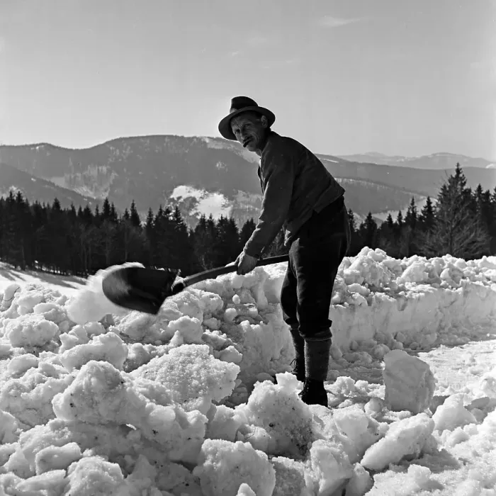 Gerahmter Druck : Winter. Ein Mitarbeiter des Feldbergerhof-Hotels schneidet den Schnee weg