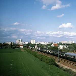 Autobahn, Autobus, Zug, Züge in grüner Landschaft mit Stadt im Hintergrund