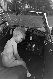 Un niño en un automóvil, Alemania 1930.