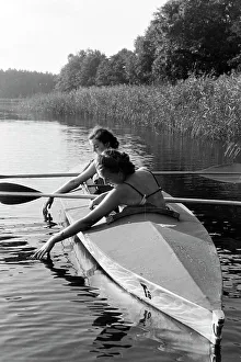 Due giovani donne in costume da bagno remano su un Klepper T6 in un lago, Germania 1930.