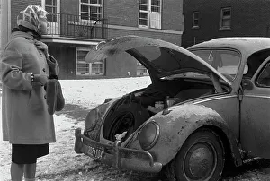 Una donna guarda nel bagagliaio di una Volkswagen Beetle.